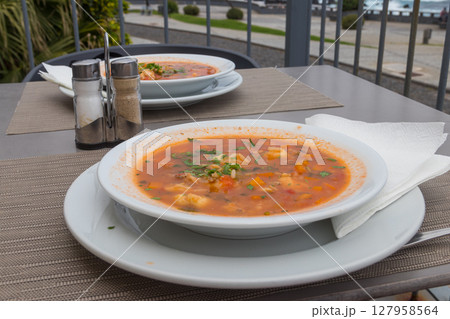 Fish soup on a table in a restaurant Fish soup on a table in a restaurant 127958564