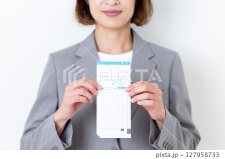 タイムカードを持つスーツ姿のミドル女性 127958733