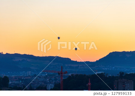 Hot air balloons flying over Bern city during sunrise, Switzerland Hot air balloons flying over Bern city during sunrise, Switzerland 127959133