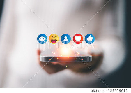 Concept of social business technology ai digital creation features website sticker, heart and like buttons, phone emojis, People express feel icon. contact hand on laptop and mobile device on desk. 127959612