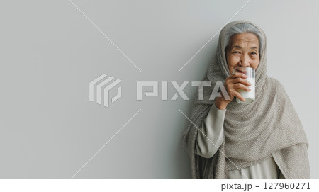 Indonesian grandmother enjoying milk in her home Indonesian grandmother enjoying milk in her home 127960271