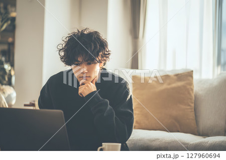 自宅で思索にふける若いアジア人男性。リラックスした日常のひとコマ 127960694