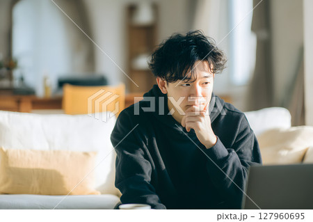 自宅で思索にふける若いアジア人男性。リラックスした日常のひとコマ 127960695