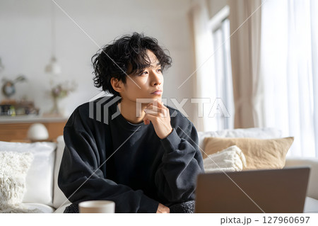 自宅で思索にふける若いアジア人男性。リラックスした日常のひとコマ 127960697