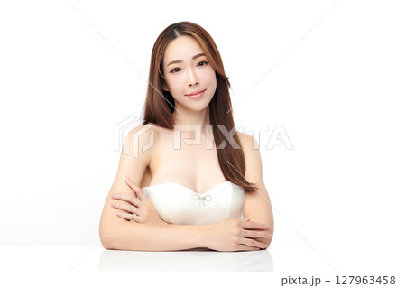 A beautiful young Asian woman with clean, fresh skin against a white background. Skincare, facial treatment, cosmetology, beauty, and spa. An elegant portrait of an Asian woman. 127963458
