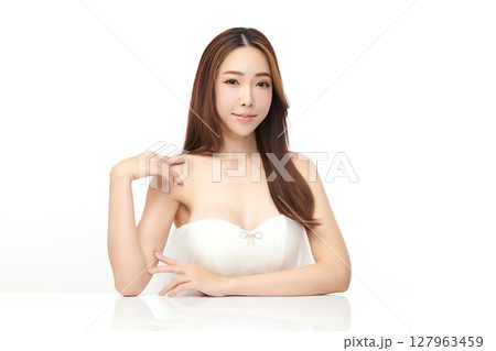 A beautiful young Asian woman with clean, fresh skin against a white background. Skincare, facial treatment, cosmetology, beauty, and spa. An elegant portrait of an Asian woman. 127963459