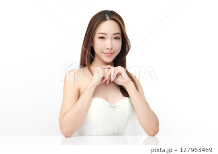 A beautiful young Asian woman with clean, fresh skin against a white background. Skincare, facial treatment, cosmetology, beauty, and spa. An elegant portrait of an Asian woman. A beautiful young Asian woman with clean, fresh skin against a white background. Skincare, facial treatment, cosmetology, beauty, and spa. An elegant portrait of an Asian woman. 127963469