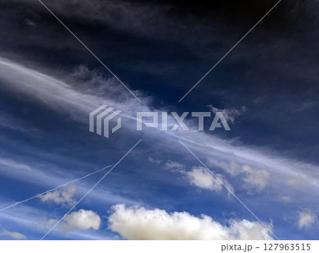 Close up of atmospheric blue black sky with whispy white clouds Close up of atmospheric blue black sky with whispy white clouds 127963515