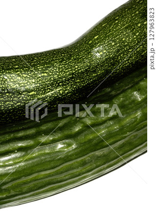 Close up of home grown cucumber courgette zucchini baby marrow vegetable skin  green on white background Close up of home grown cucumber courgette zucchini baby marrow vegetable skin  green on white background 127963823