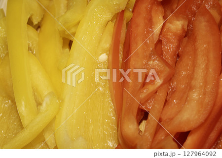 Close up of red pepper and carrot finely cut vegetable slices for cooking Close up of red pepper and carrot finely cut vegetable slices for cooking 127964092