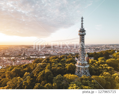 Golden light bathes Petrin Lookout Tower as the sun rises over Prague. Surrounded by lush greenery and the city skyline, this moment captures the beauty of early morning tranquility. Golden light bathes Petrin Lookout Tower as the sun rises over Prague. Surrounded by lush greenery and the city skyline, this moment captures the beauty of early morning tranquility. 127965715
