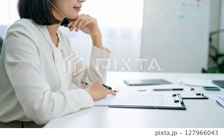 契約書を見てうなずくビジネスパーソン 127966043