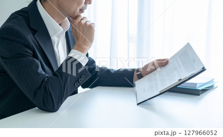 契約書を見てうなずくビジネスパーソン 127966052