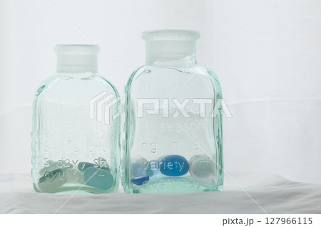 窓際の白いカーテンの前にある二本のガラス瓶 窓際の白いカーテンの前にある二本のガラス瓶 127966115