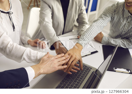 Group of employees of different nationalities folds their hands as a symbol of unity 127966304