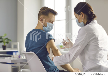 Male patient getting injection vaccination from nurse in clinic Male patient getting injection vaccination from nurse in clinic 127966677