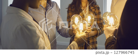 Business people join light bulbs as metaphor for sharing ideas in creative community 127966745