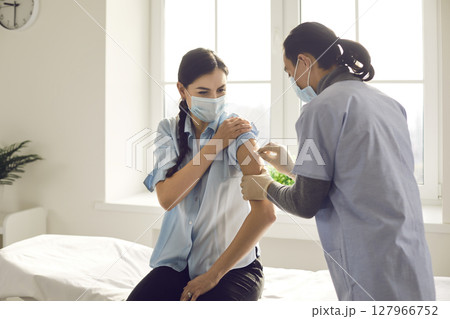 Doctor prepares the patient's hand for the introduction of the coronavirus vaccine. Doctor prepares the patient's hand for the introduction of the coronavirus vaccine. 127966752