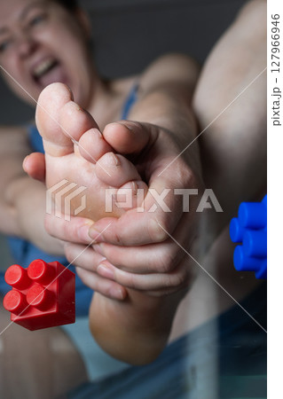 Constructor Experiences Foot Pain While Handling Toys at Home With a Child Constructor Experiences Foot Pain While Handling Toys at Home With a Child 127966946