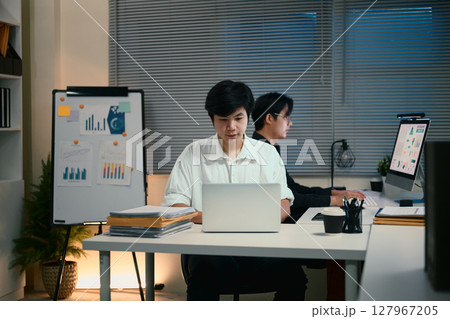 Two young businessmen working overtime in a modern office 127967205