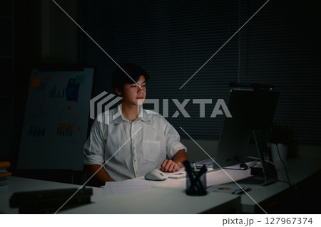 Focused businessman staying late to complete important projects,in a dimly lit office. Focused businessman staying late to complete important projects,in a dimly lit office. 127967374