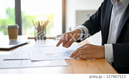 資料を指差すビジネスパーソンの手元  127967523