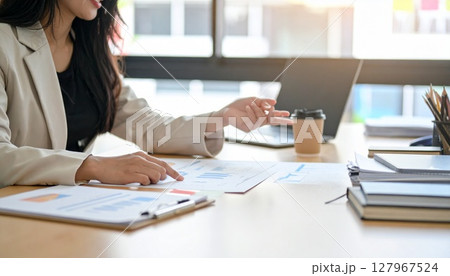 資料を指差すビジネスパーソンの手元  127967524