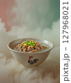 Hearty bowl of Asian pork gruel or congee, topped with fresh scallions and crunchy fried garlic, presented in a rustic ceramic bowl. 127968021