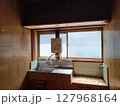 昭和型板ガラスの窓と古い流し台やガスの元栓があり水回りの壁にタイルが貼られた昭和の台所 127968164