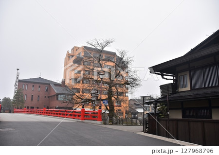 日本の岐阜県　春の高山祭期間中　観光名所の中橋とつぼみ状態の桜　周辺の街並みや古民家 127968796