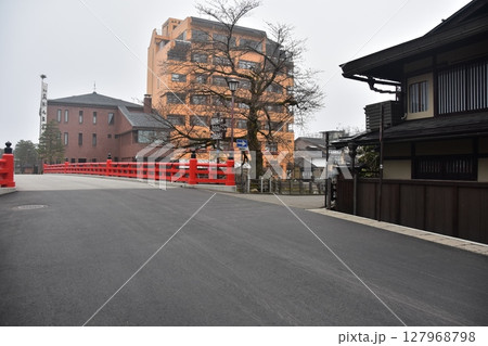 日本の岐阜県　春の高山祭期間中　観光名所の中橋とつぼみ状態の桜　周辺の街並みや古民家 127968798