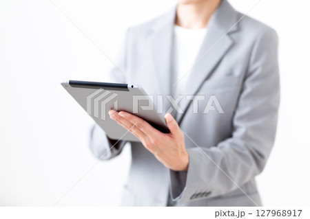 タブレットを持つグレーのスーツ姿のミドル女性 127968917