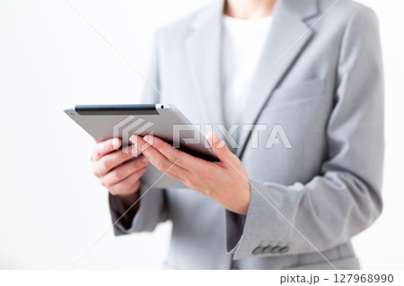 タブレットを持つグレーのスーツ姿のミドル女性 127968990