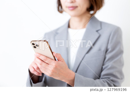 スマホを持つグレーのスーツ姿のミドル女性 スマホを持つグレーのスーツ姿のミドル女性 127969196