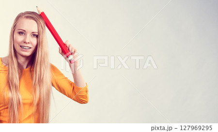 Woman holding big pencil Woman holding big pencil 127969295