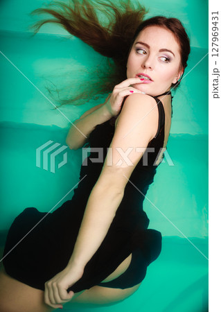 Sexy seductive woman in black dress in water. Sexy seductive woman in black dress in water. 127969431