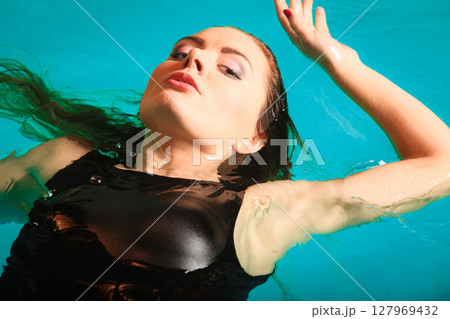 Woman floating relaxing in swimming pool water. Woman floating relaxing in swimming pool water. 127969432