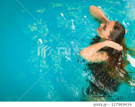 Woman floating relaxing in swimming pool water. Woman floating relaxing in swimming pool water. 127969434