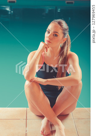 Sporty fit woman at swimming pool edge poolside. Sporty fit woman at swimming pool edge poolside. 127969455