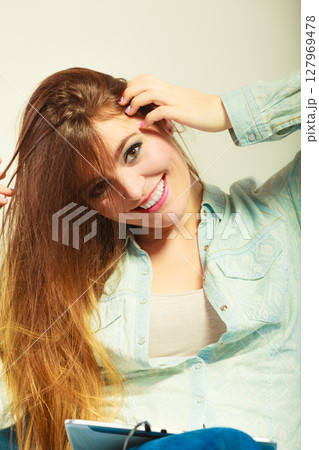 Woman with tablet headphones relaxing 127969478