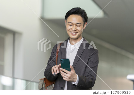スマートフォンを操作する笑顔の40代の男性 スマートフォンを操作する笑顔の40代の男性 127969539