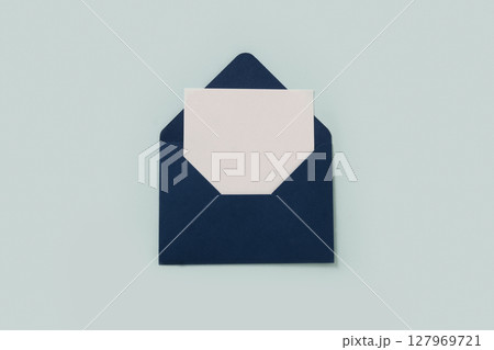 Blue elegant paper envelope and white sheet blank for letter d on blue background. Greeting card. Copy space. View from above. 127969721