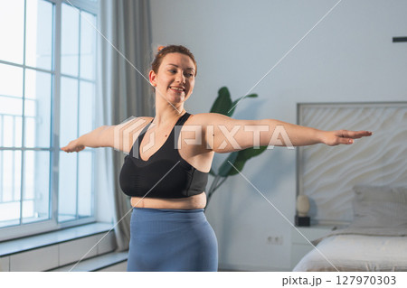 Fitness workout training. Woman practicing fitness at home. Plus size female doing sports exercise at home indoor. Girl in sportswear have workout weight training for weight loss. Sport and fitness 127970303