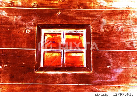 A small window in the wall of an old wooden house, changed colors. A small window in the wall of an old wooden house, changed colors. 127970616