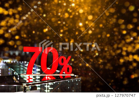 70 percent discount with golden bokeh background. Discounts in the shopping center. Seasonal sale, black friday. Red label. 127970747
