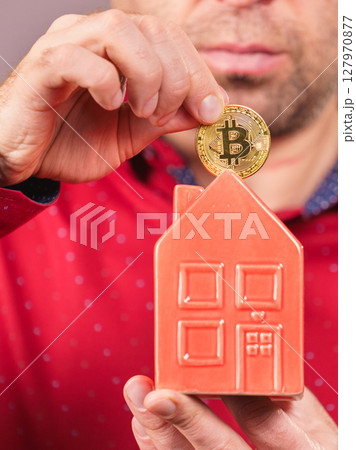 Man paying his house rent using bitcoin Man paying his house rent using bitcoin 127970877