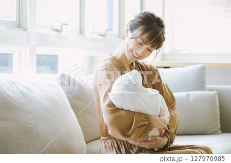 赤ちゃんを抱く若い母親 127970985
