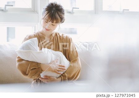 赤ちゃんを抱く若い母親 127971045