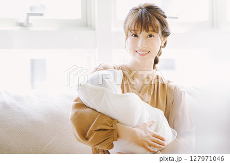 赤ちゃんを抱く若い母親 赤ちゃんを抱く若い母親 127971046