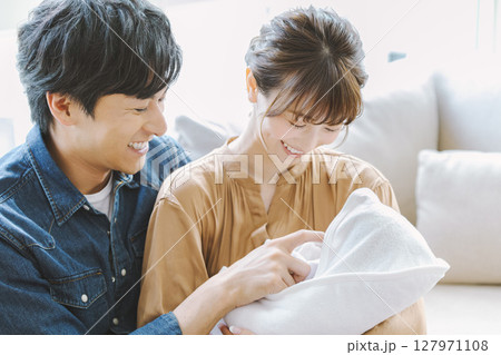 赤ちゃんを抱っこしたママとパパ 127971108